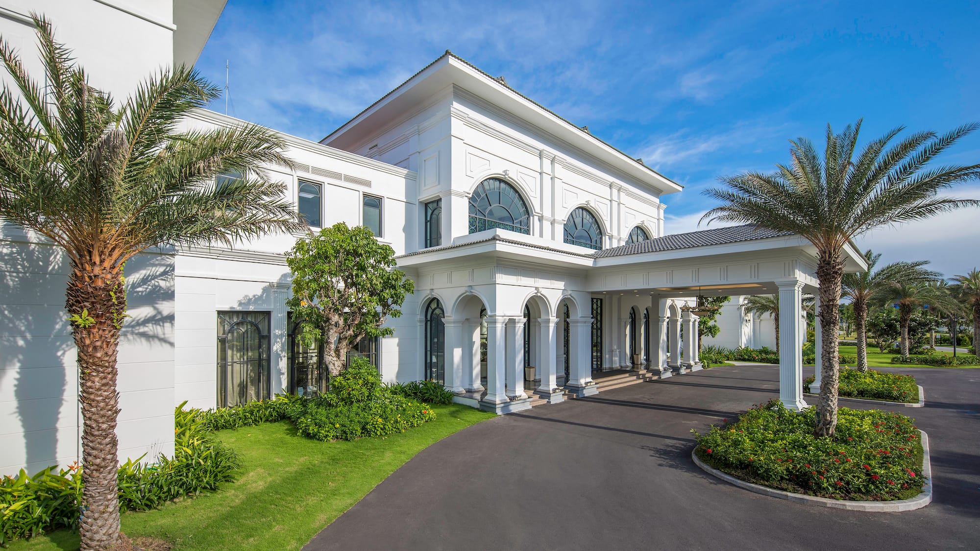 a white building with columns and a driveway