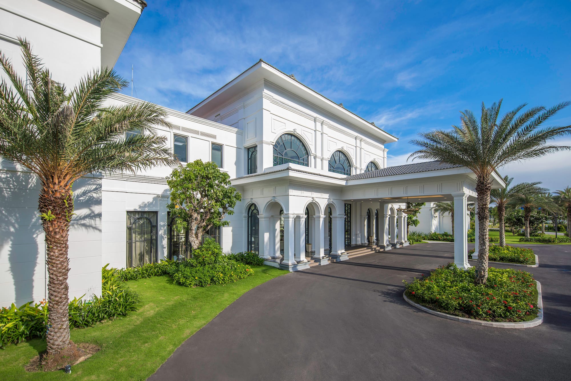 a white building with columns and a driveway