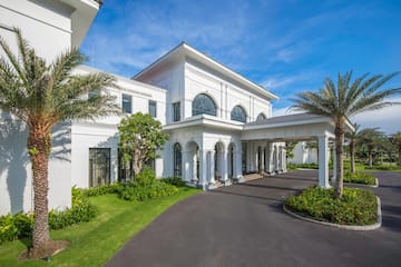 a white building with columns and a driveway