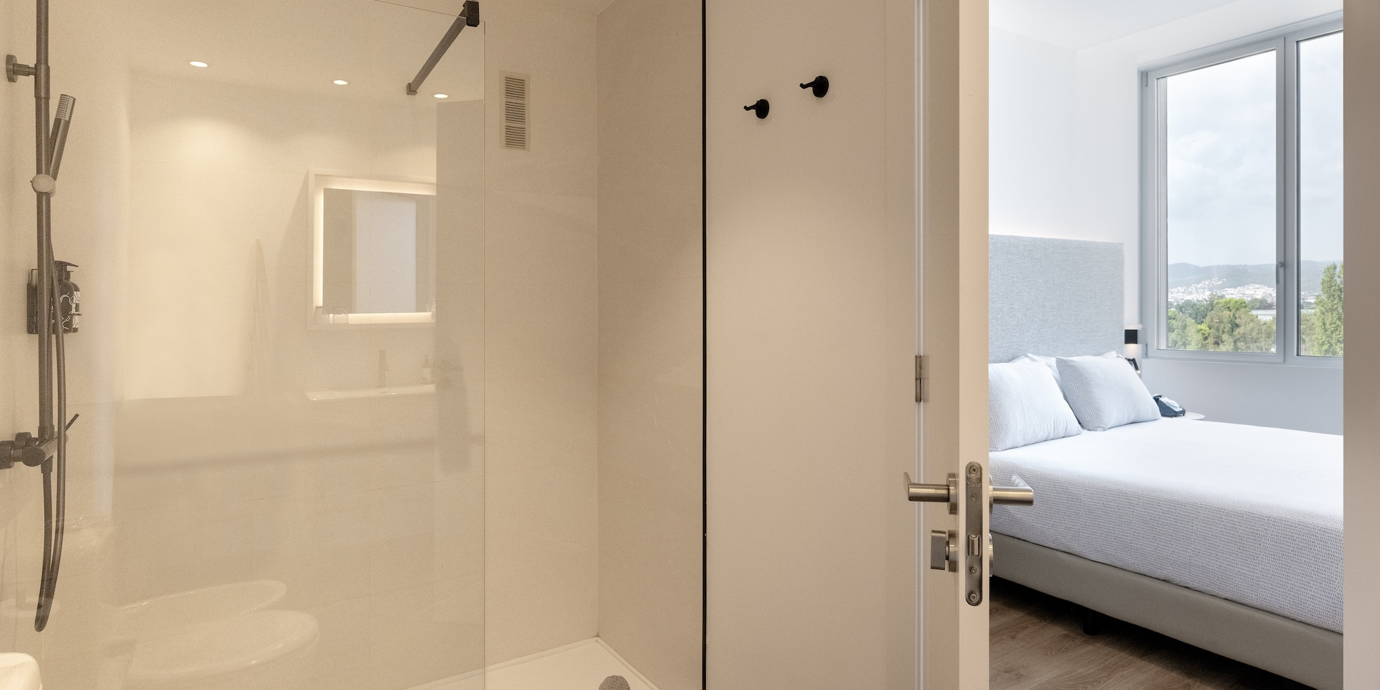 a bathroom with a glass shower and a bed
