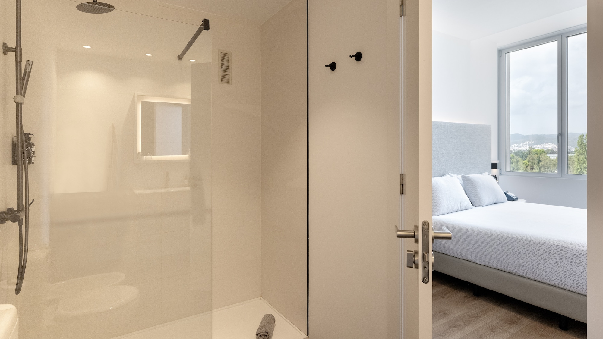 a bathroom with a glass shower and a bed