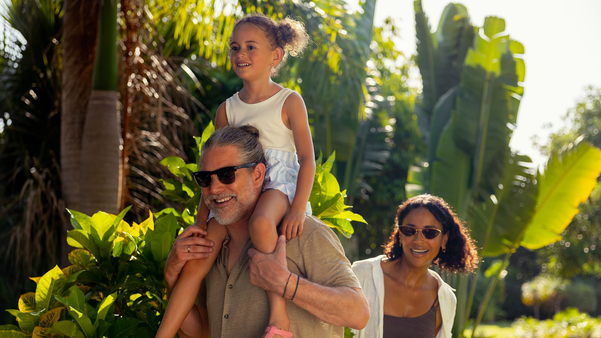 a man carrying a girl on his shoulders
