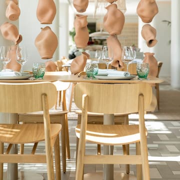 a table with chairs and vases from the ceiling