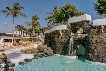 a pool with a waterfall and palm trees