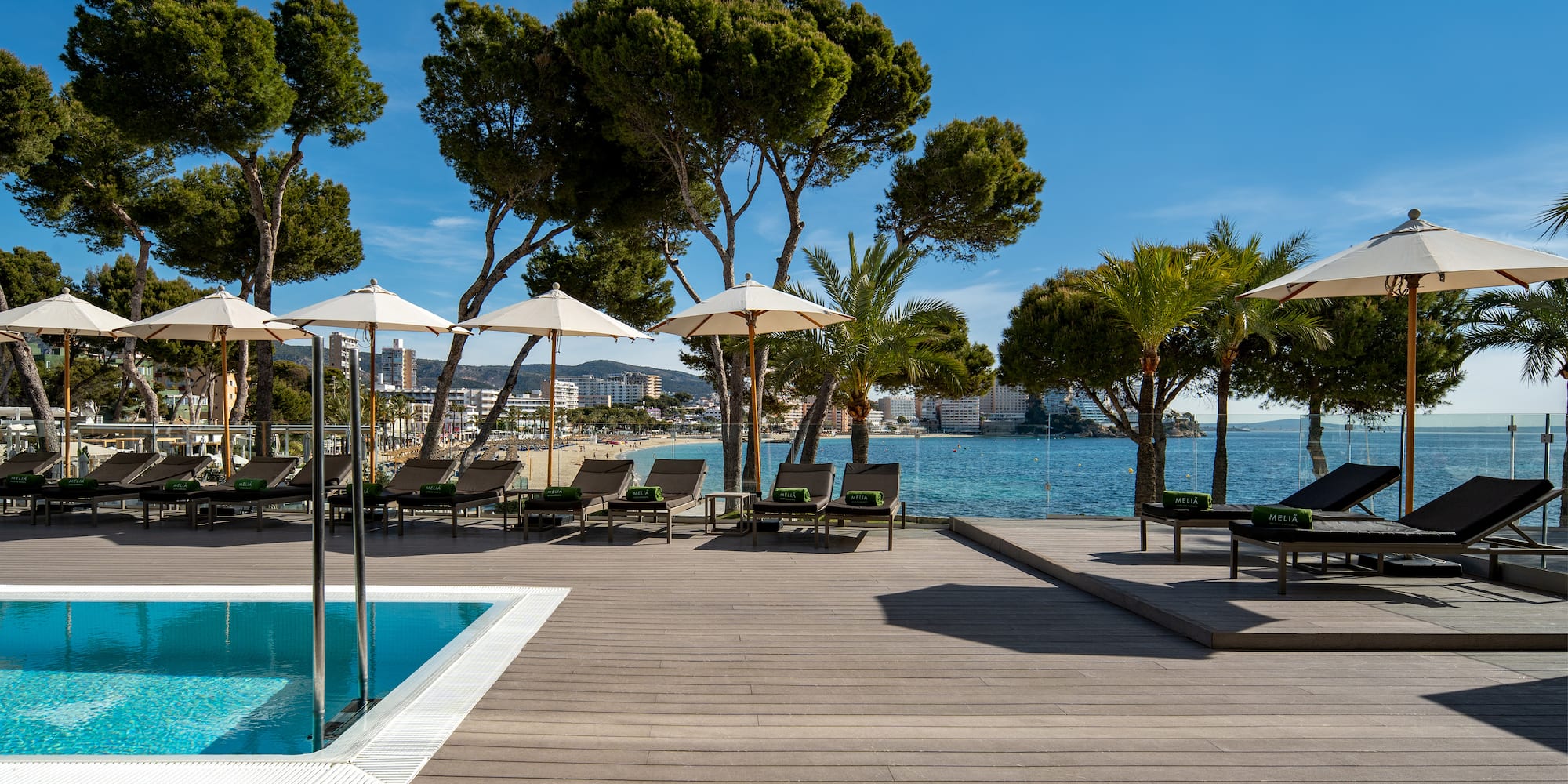 a pool with umbrellas and chairs on a deck
