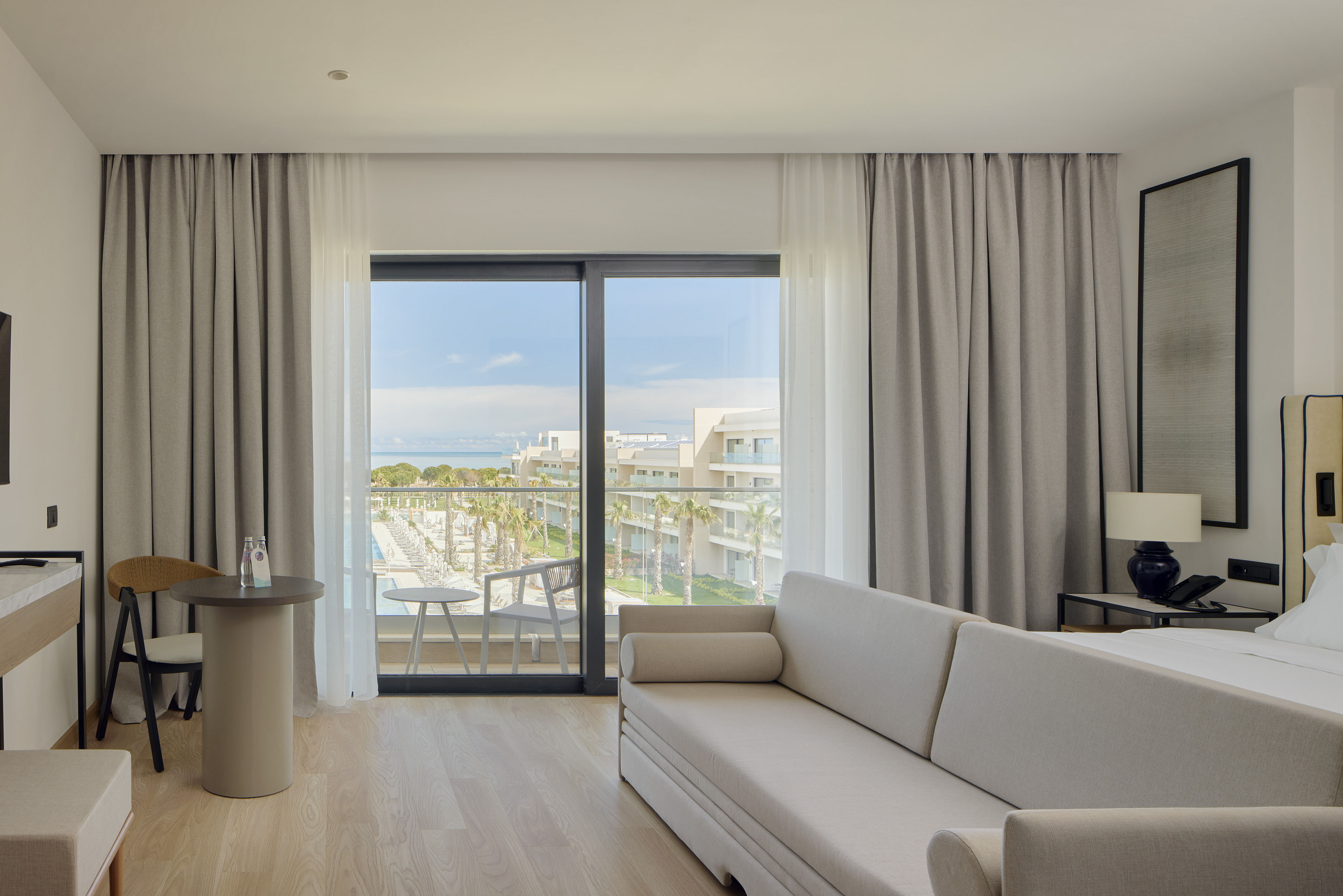 a room with a couch and a table and a table with a view of the ocean