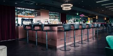 a bar with chairs and a chandelier