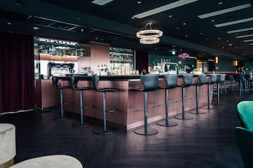 a bar with chairs and a chandelier