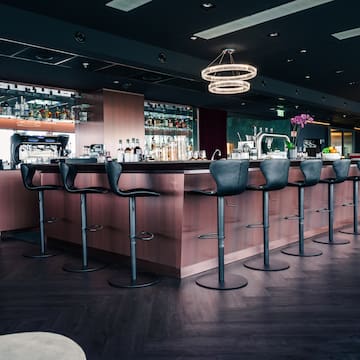 a bar with chairs and a chandelier