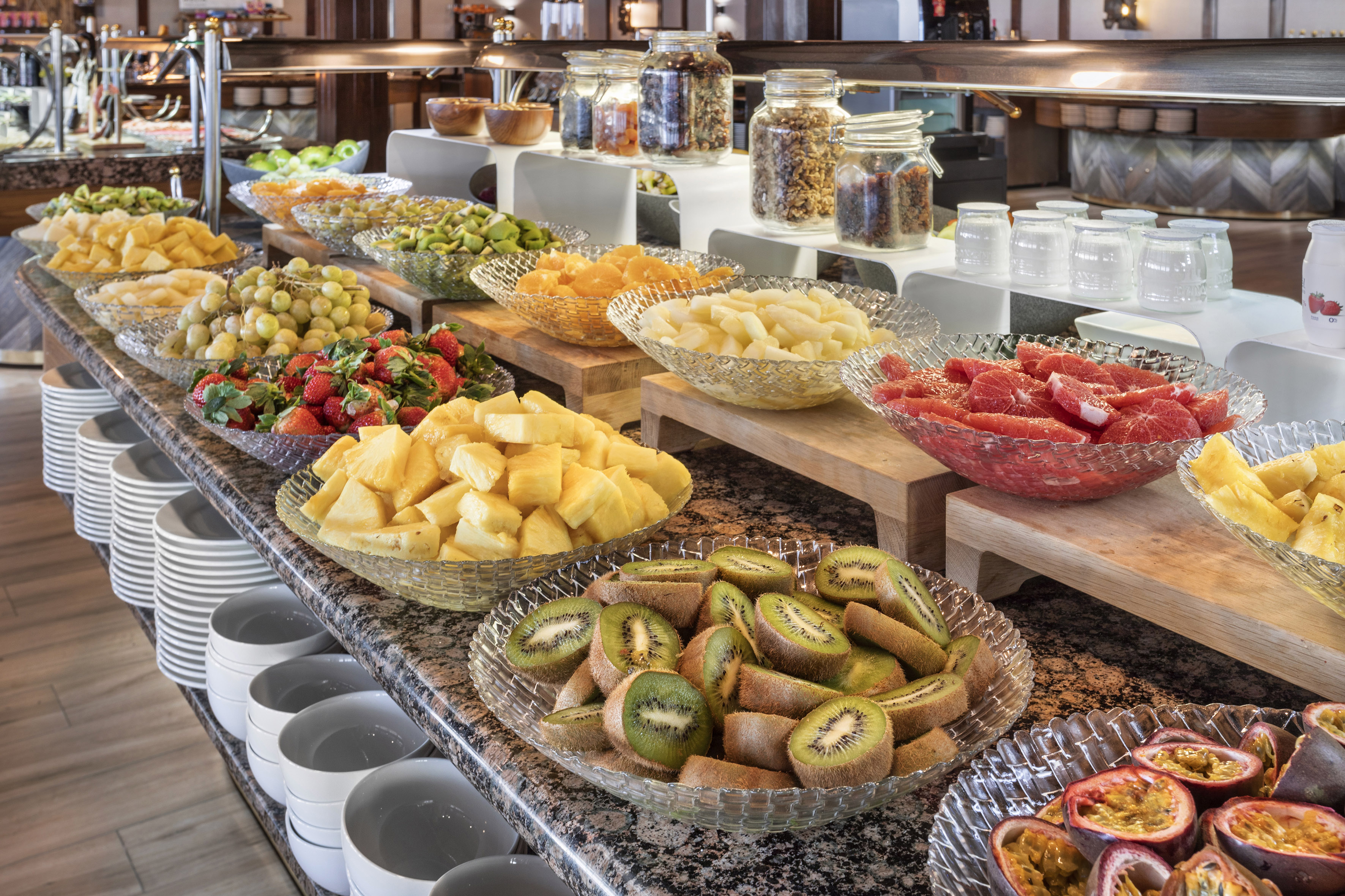 Healthy fruit buffet with pineapple, kiwi, strawberries, grapes, and nuts.