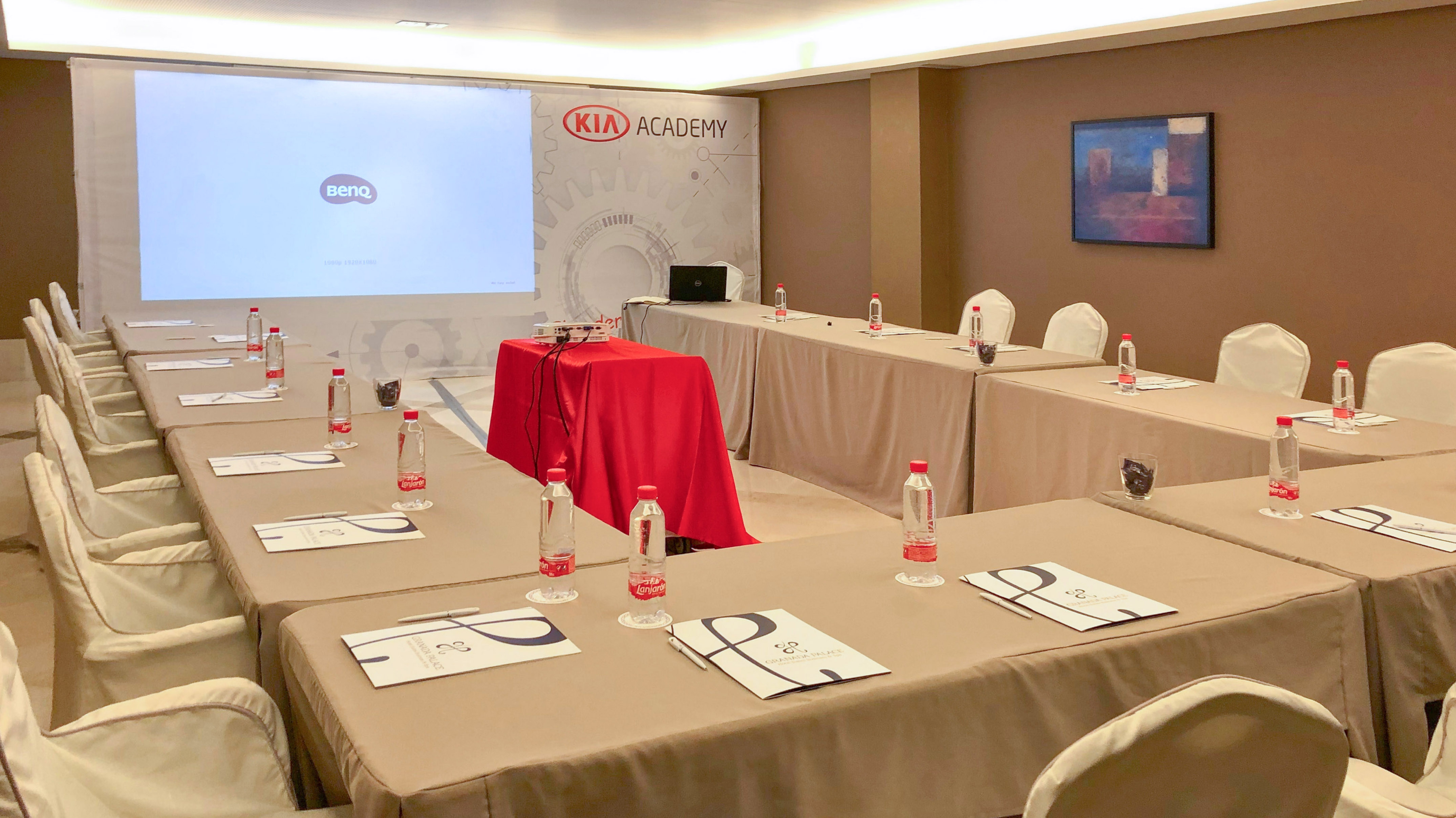 Kia Academy conference room, projector screen, and U-shaped meeting tables.