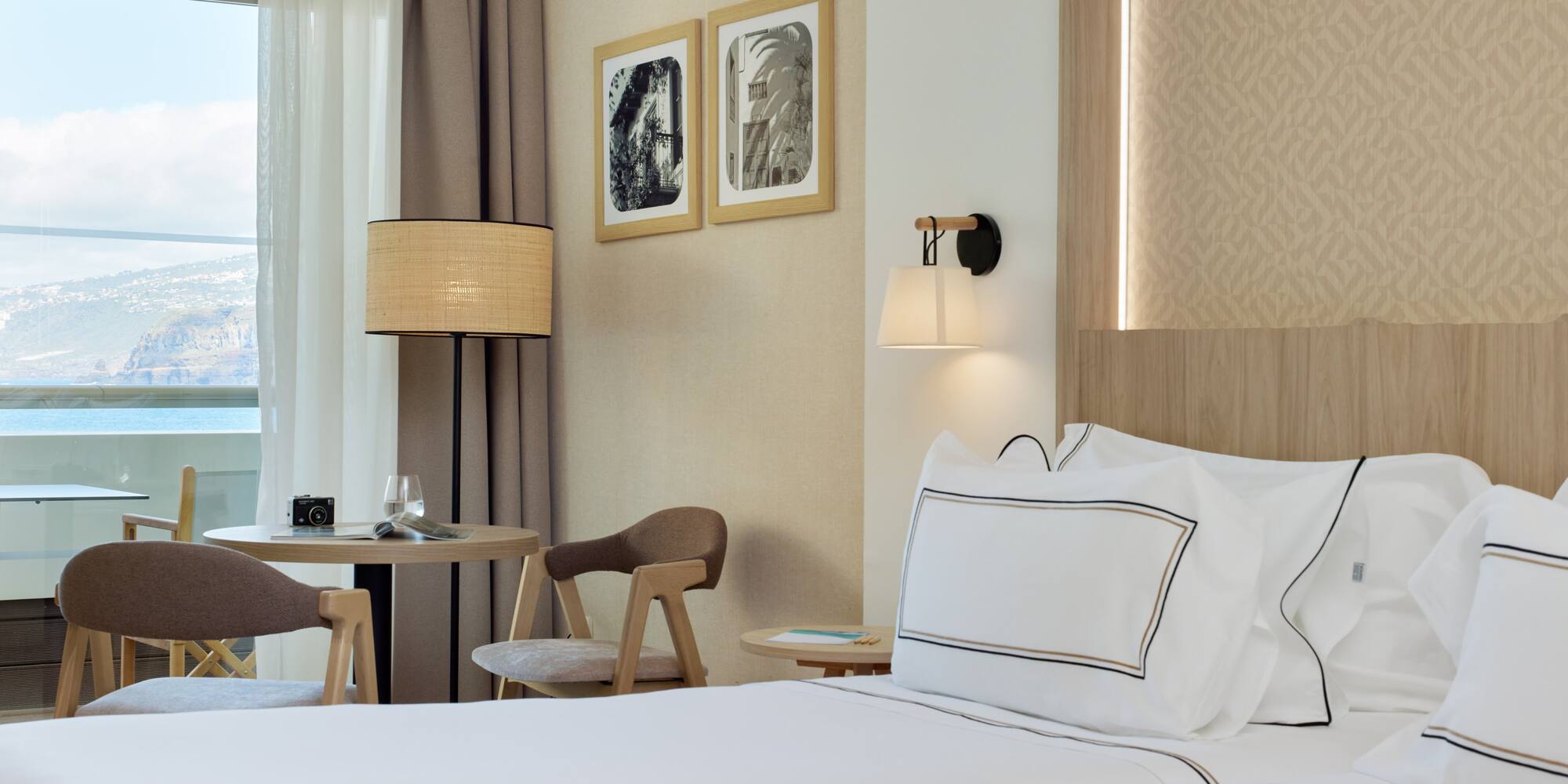 a bed with white sheets and a table in a hotel room