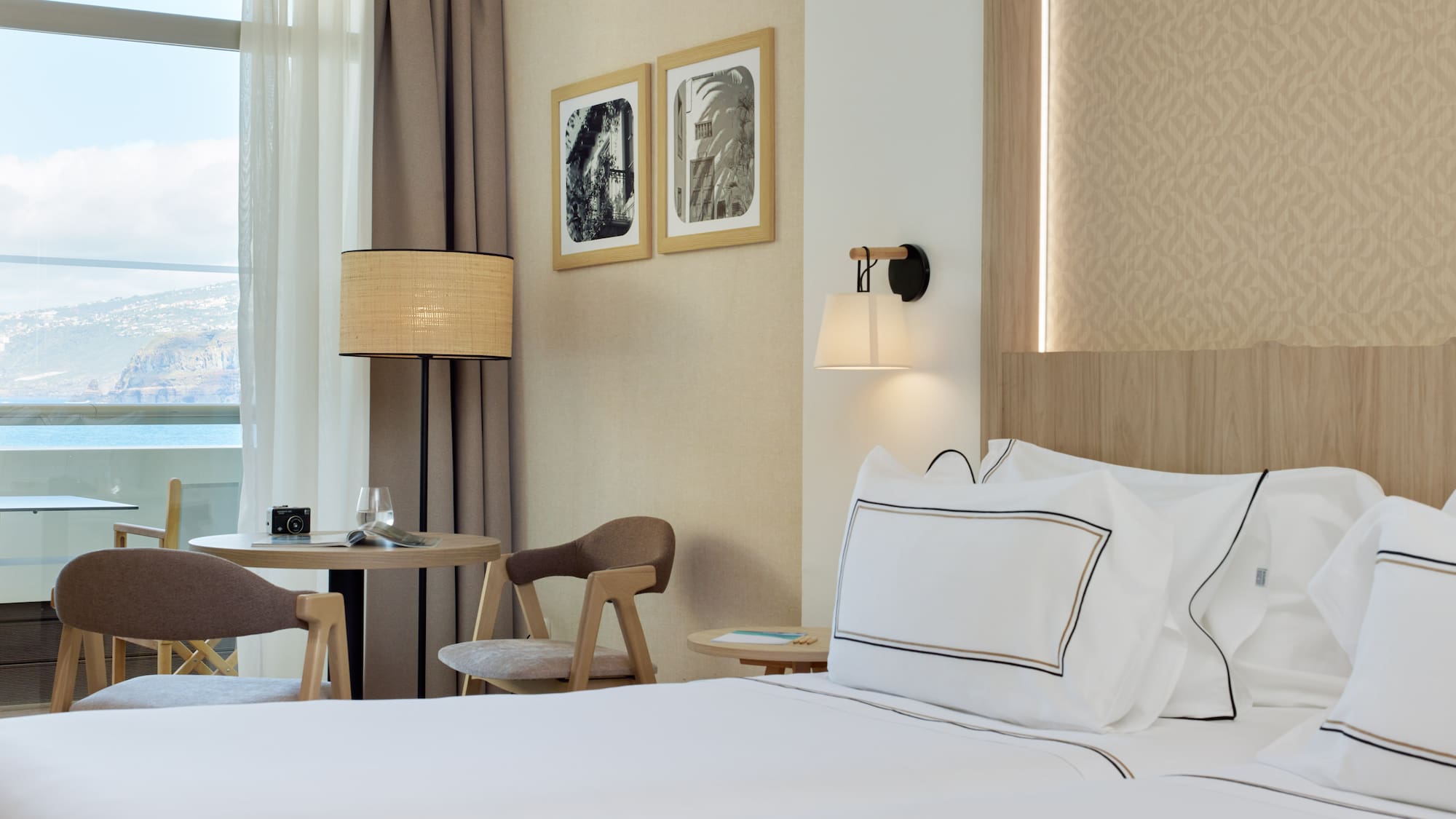 a bed with white sheets and a table in a hotel room