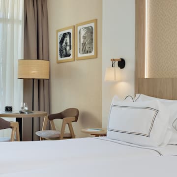 a bed with white sheets and a table in a hotel room