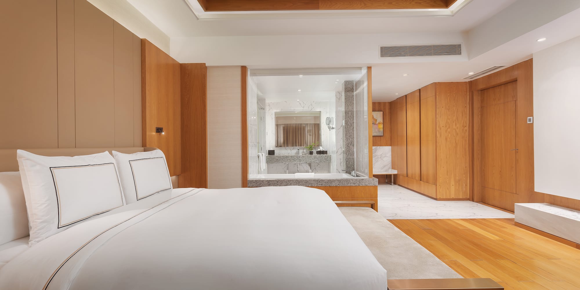 a bedroom with wood cabinets and a white bed