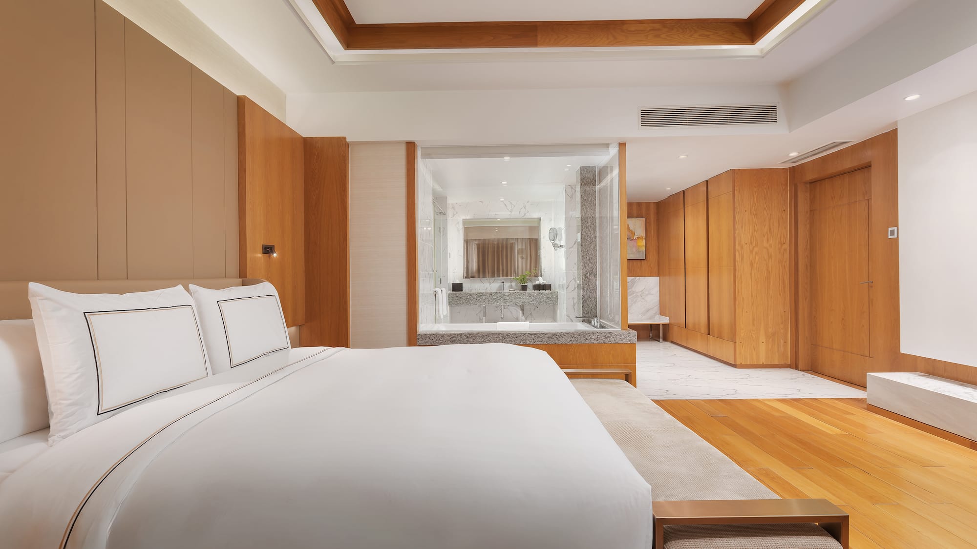 a bedroom with wood cabinets and a white bed
