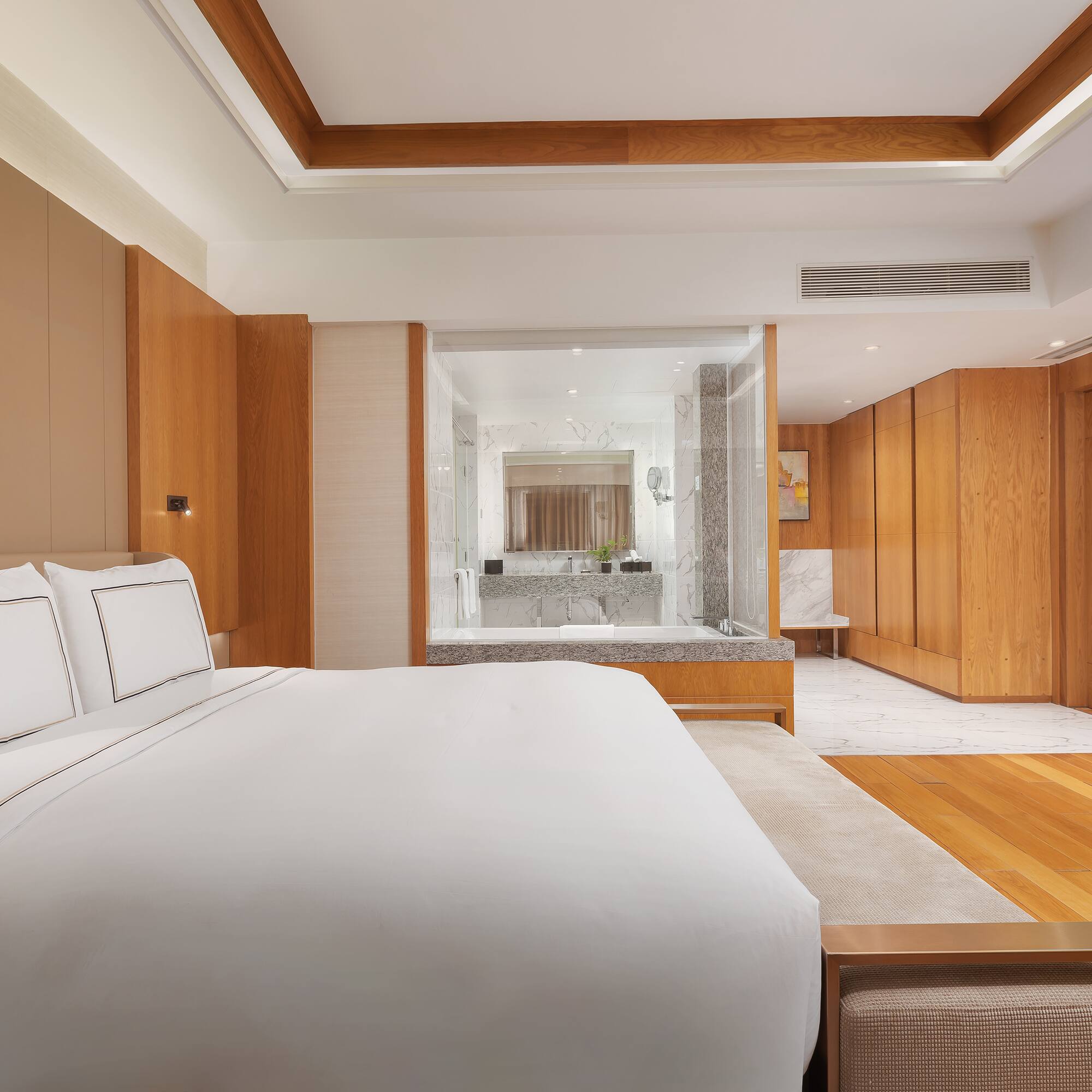 a bedroom with wood cabinets and a white bed