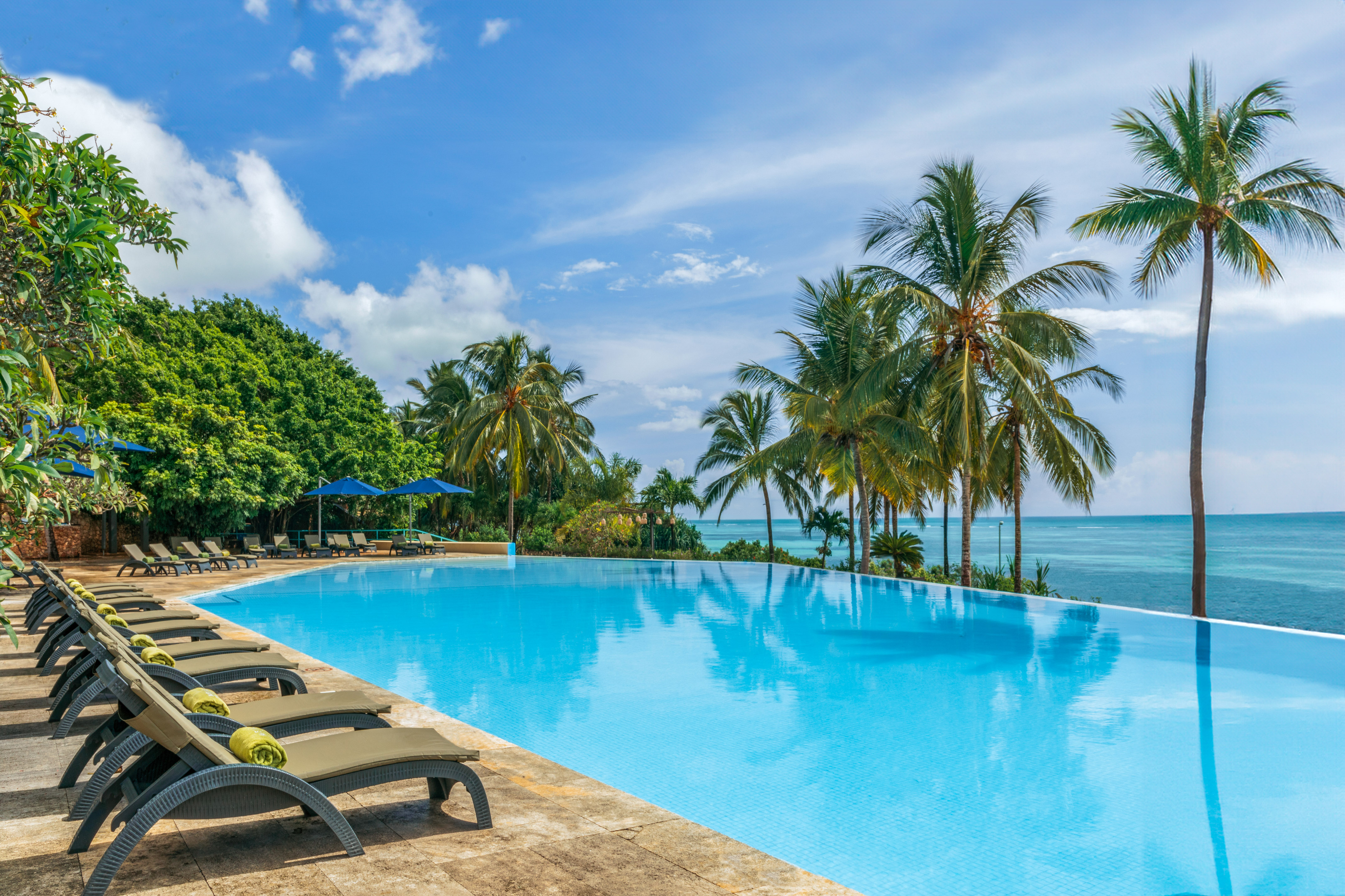 a pool with lounge chairs and palm trees