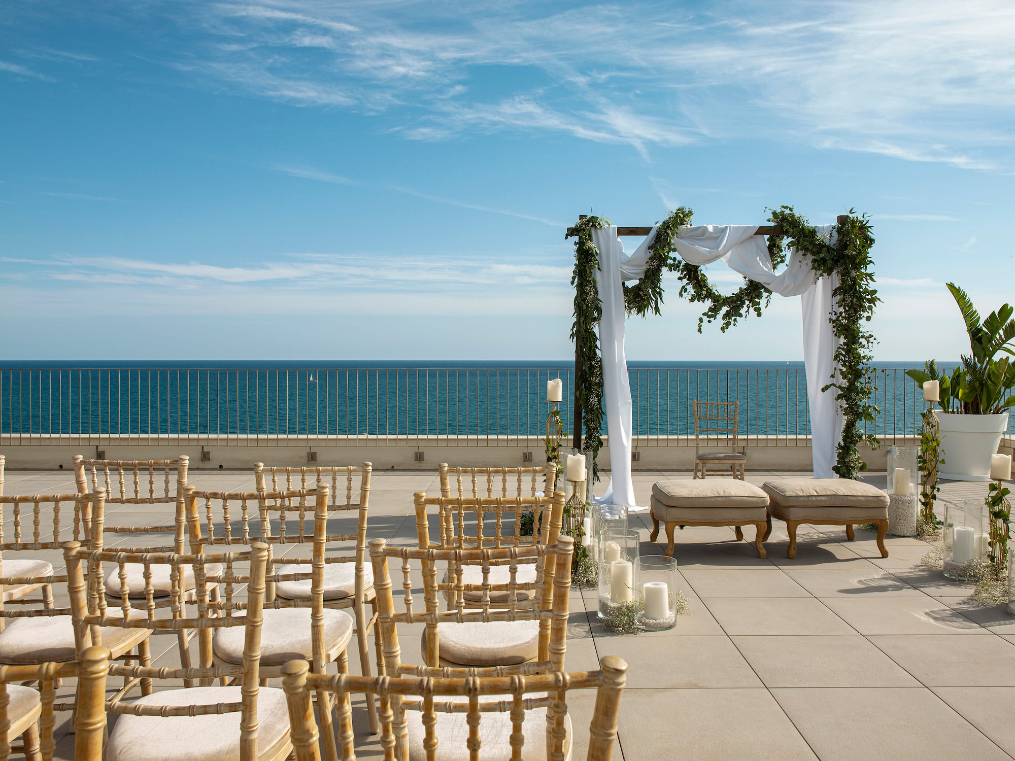 a wedding set up on a patio with chairs and a large body of water