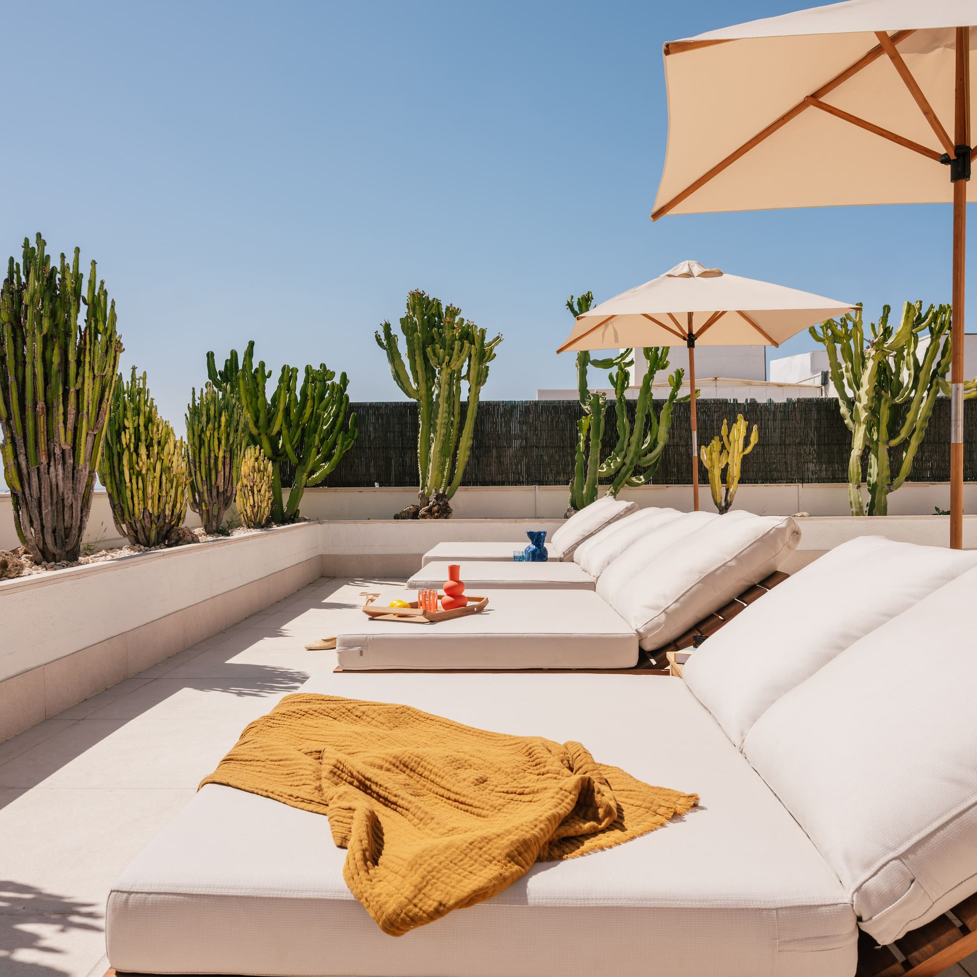 a lounge chairs and umbrellas on a patio