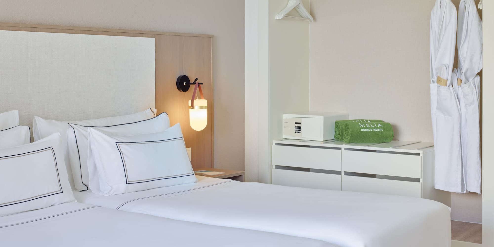 a room with two beds and a lamp