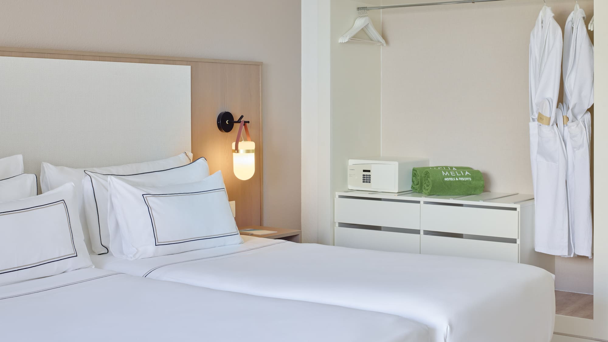 a room with two beds and a lamp