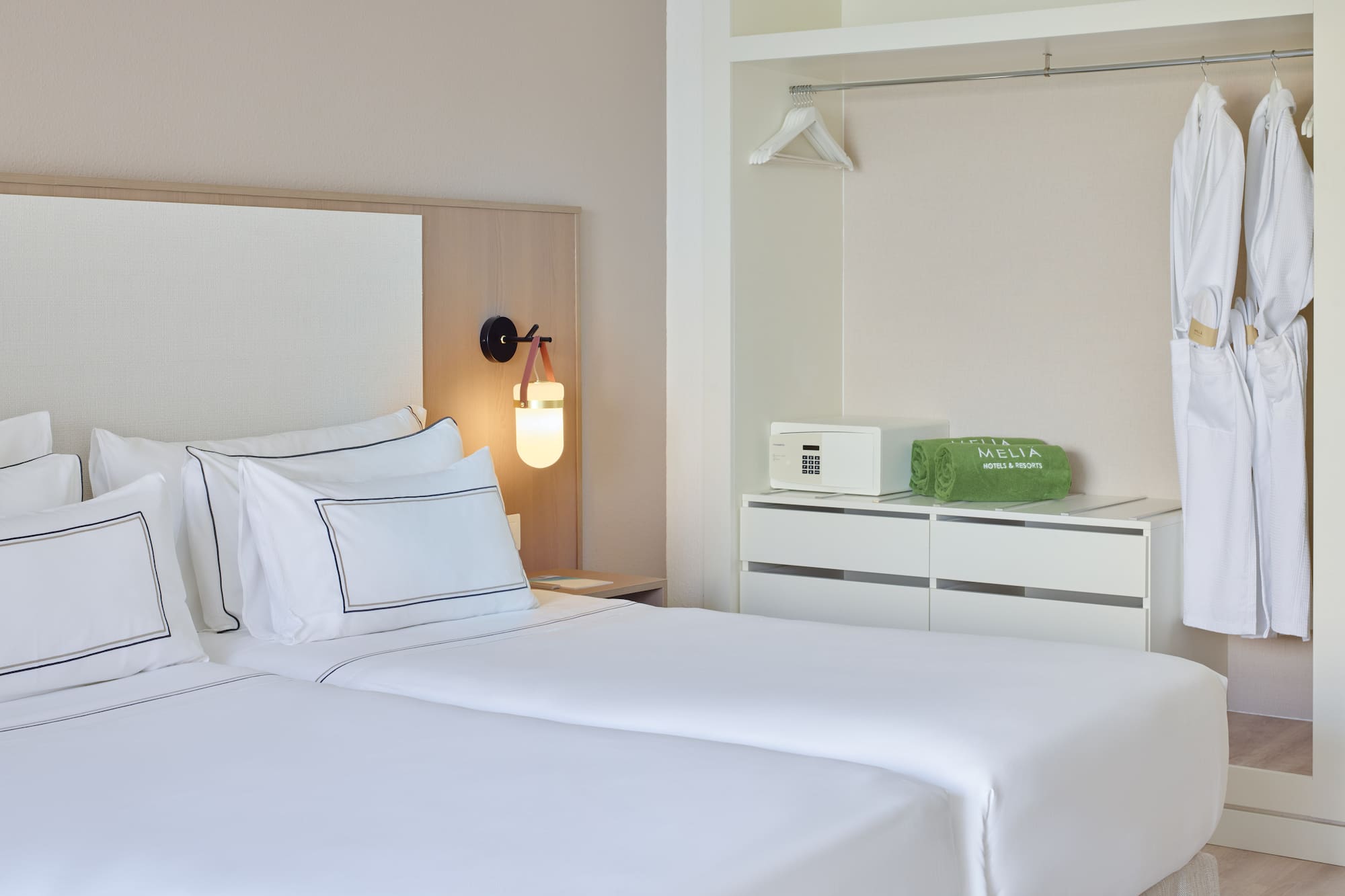 a room with two beds and a lamp