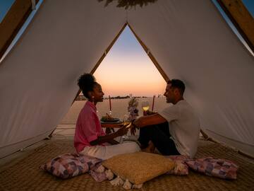 a man and woman sitting in a tent