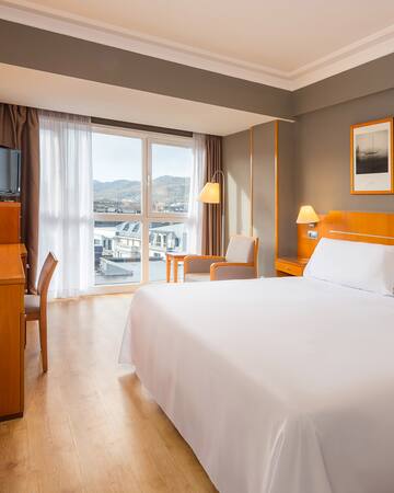 a room with a bed and a television