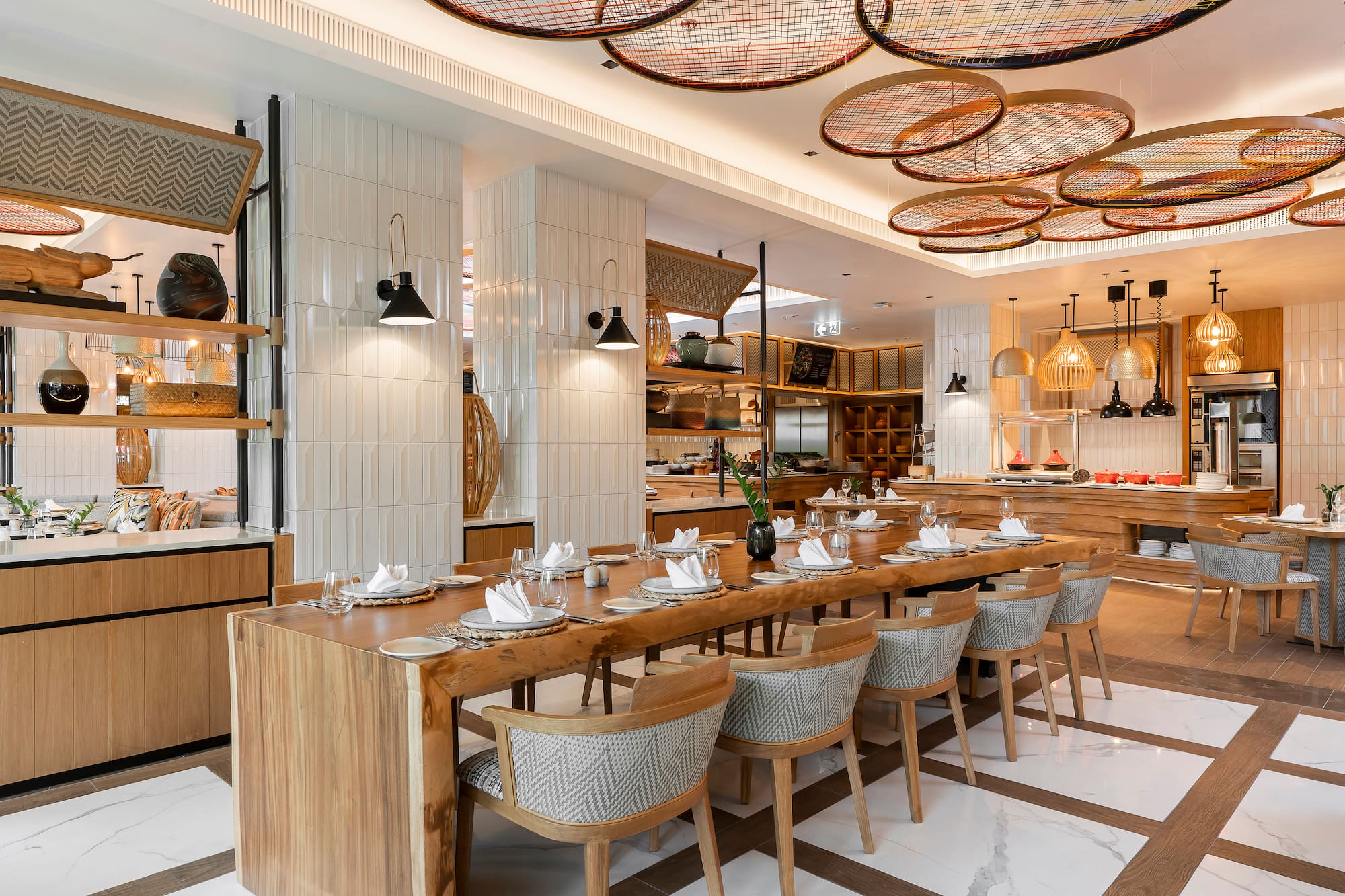 Modern restaurant dining room with communal wooden table and stylish decor.