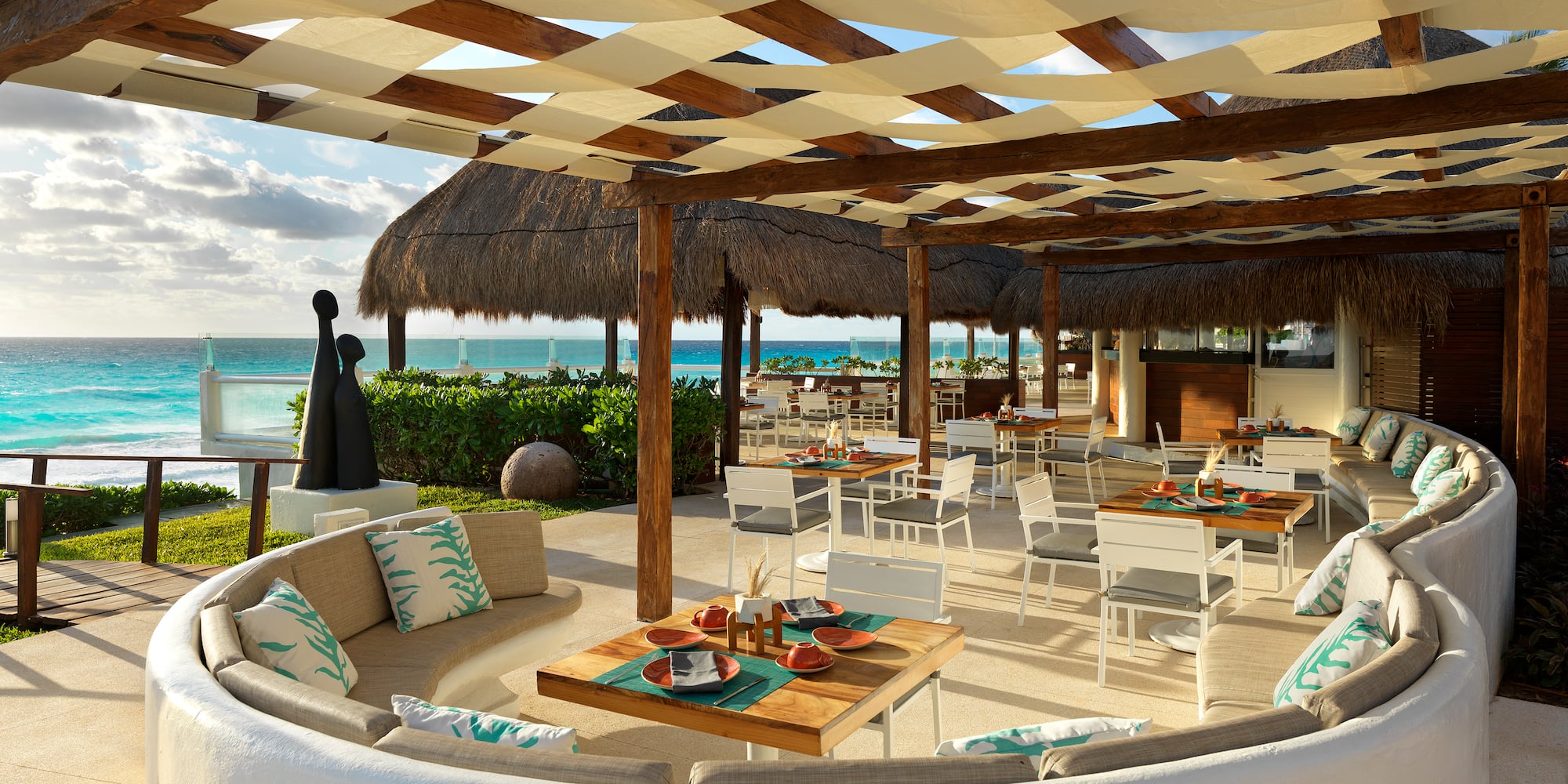 a patio with a large table and chairs and a beach