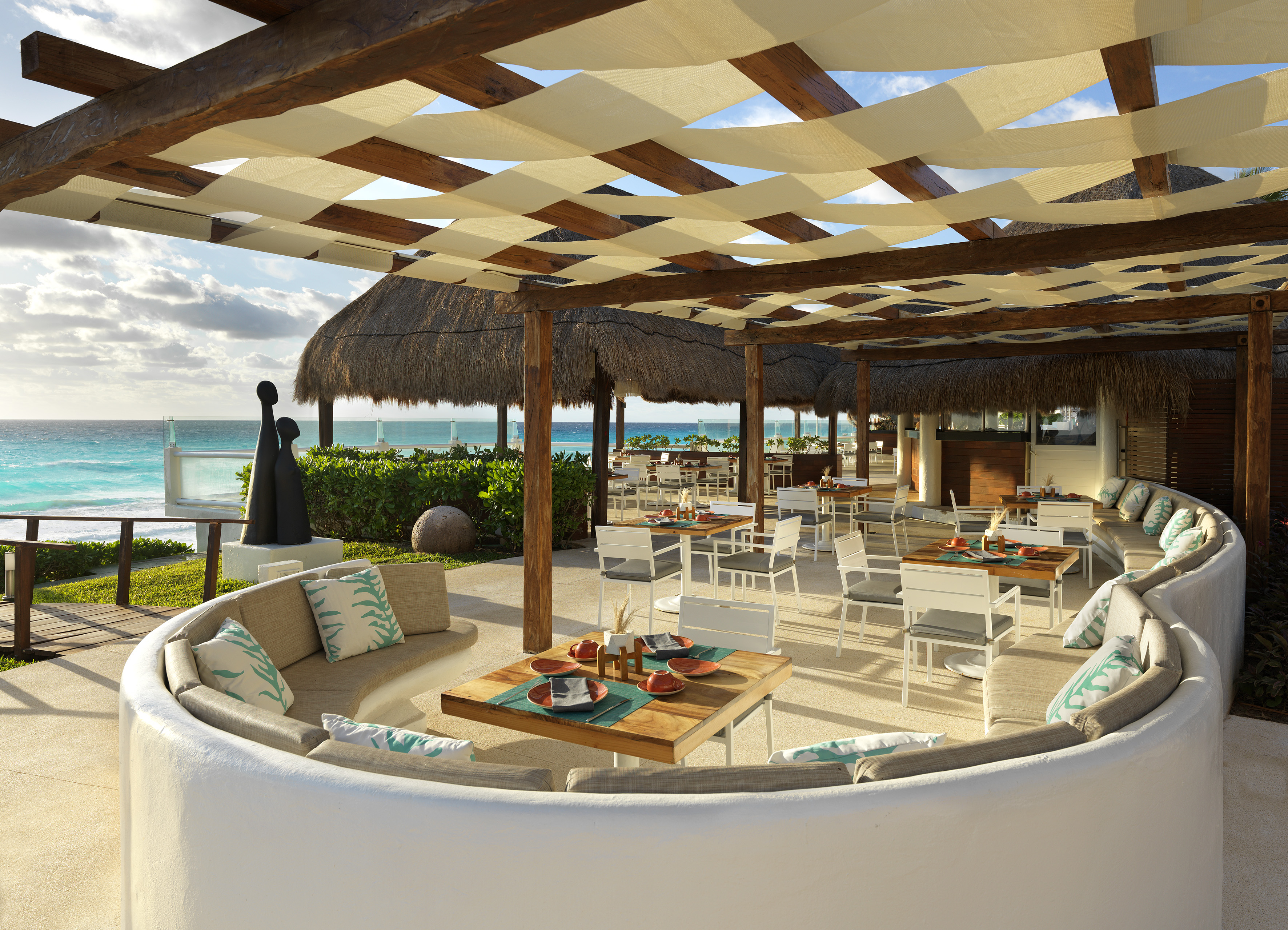 a patio with a large table and chairs and a beach
