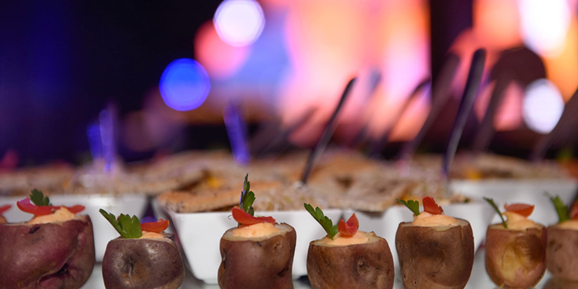 a group of baked potatoes with vegetables on them