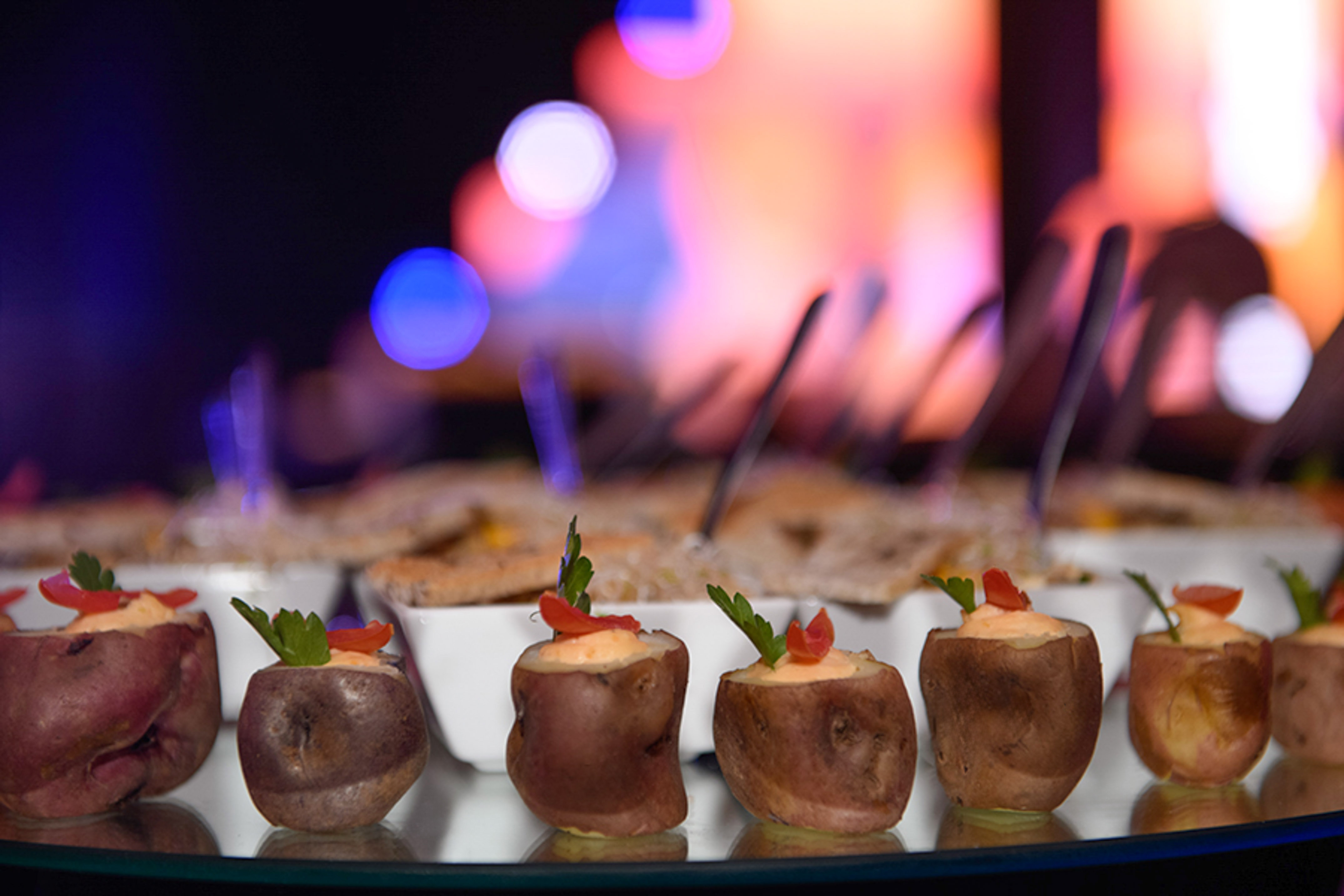 a group of baked potatoes with vegetables on them