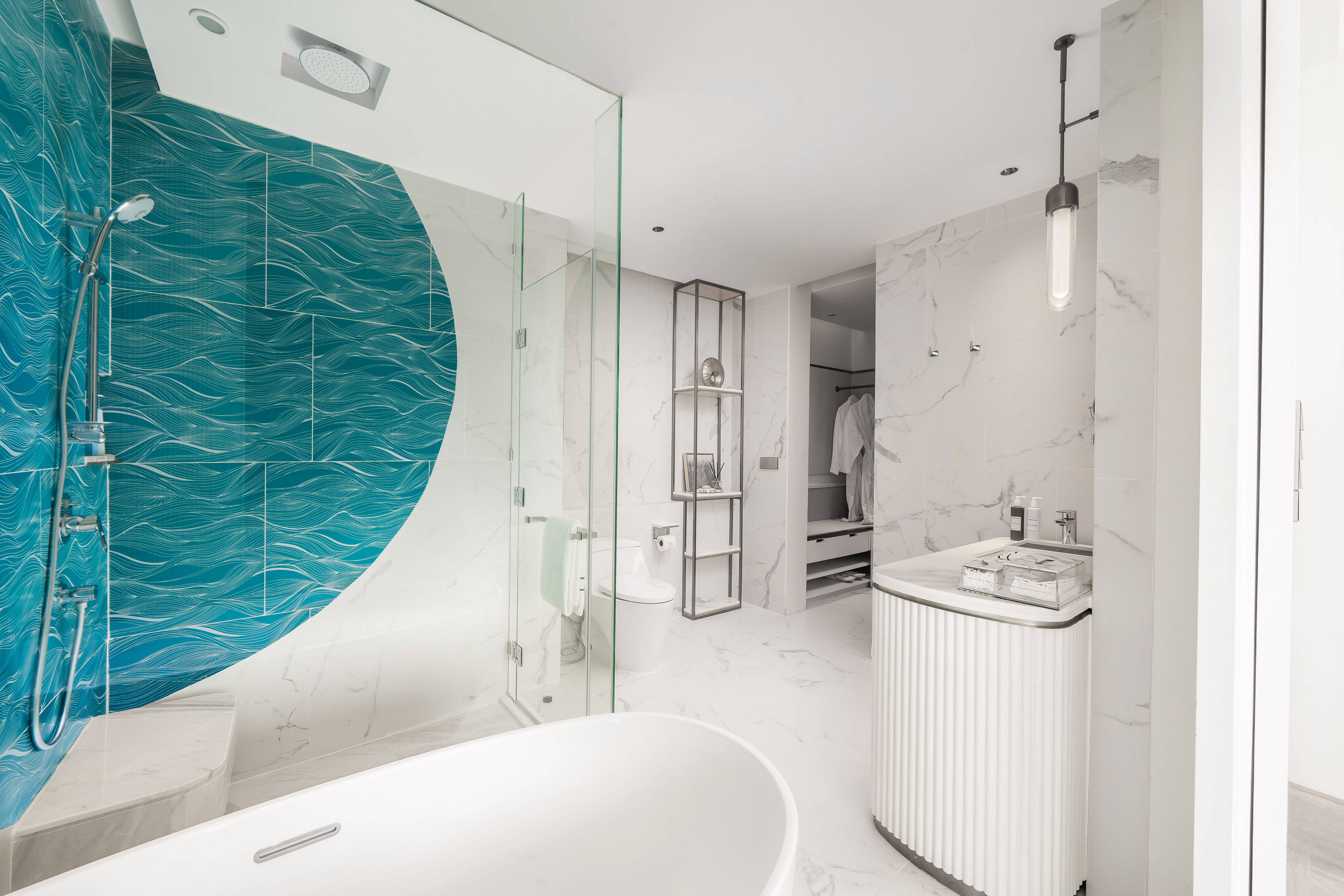 Modern luxury bathroom with teal wave tiles, freestanding tub, walk-in shower.