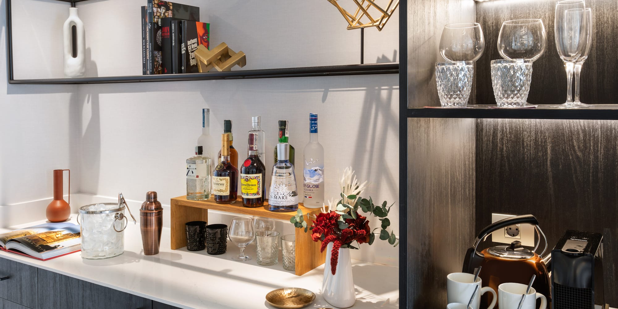 a shelf with liquor bottles and glasses on it