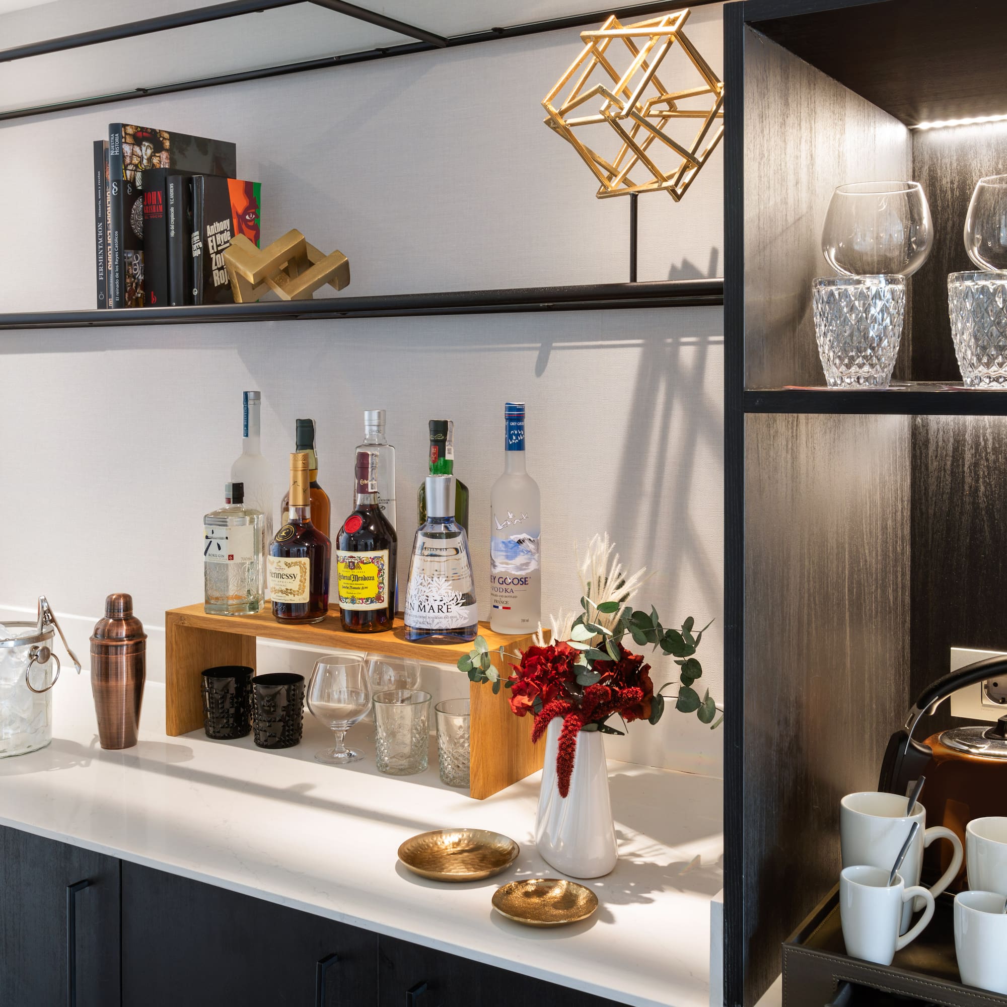 a shelf with liquor bottles and glasses on it