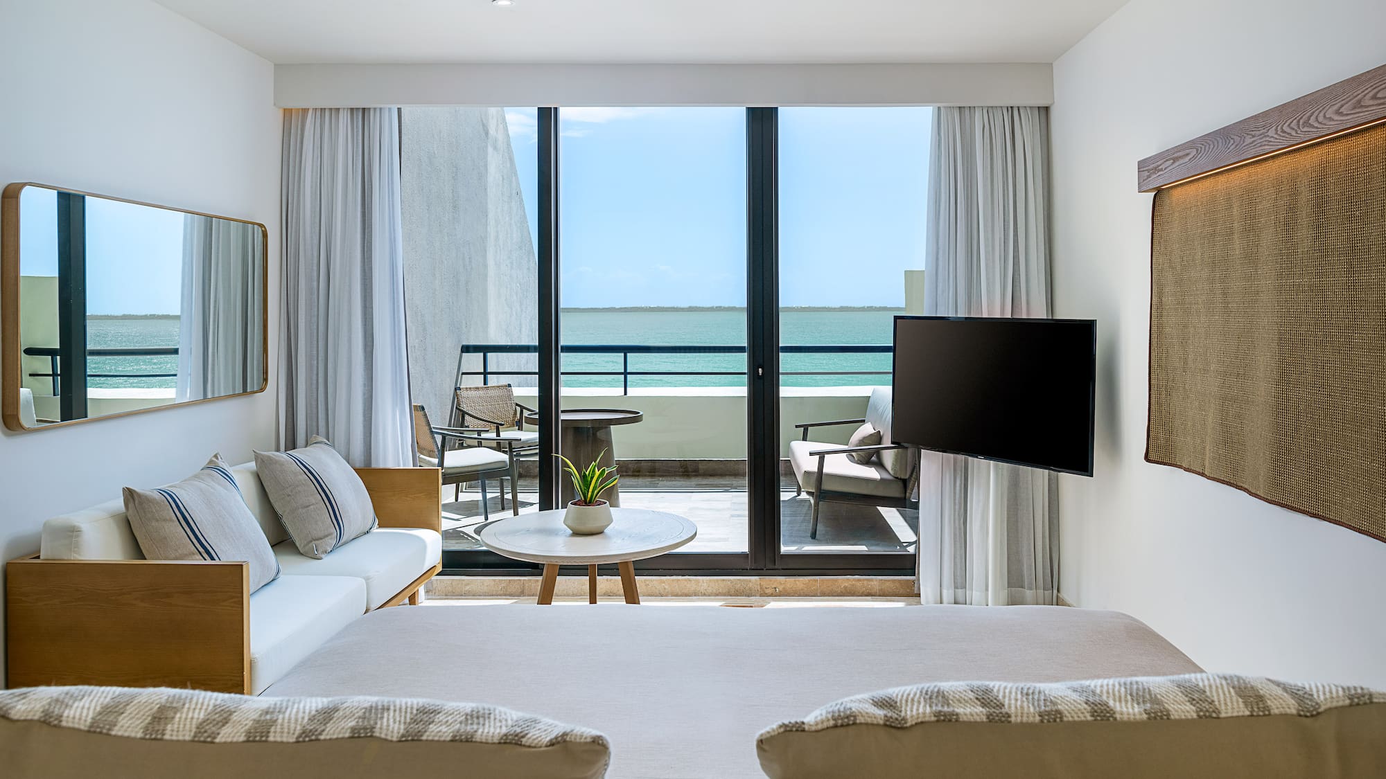 a room with a television and a view of the ocean