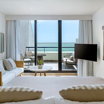a room with a television and a view of the ocean