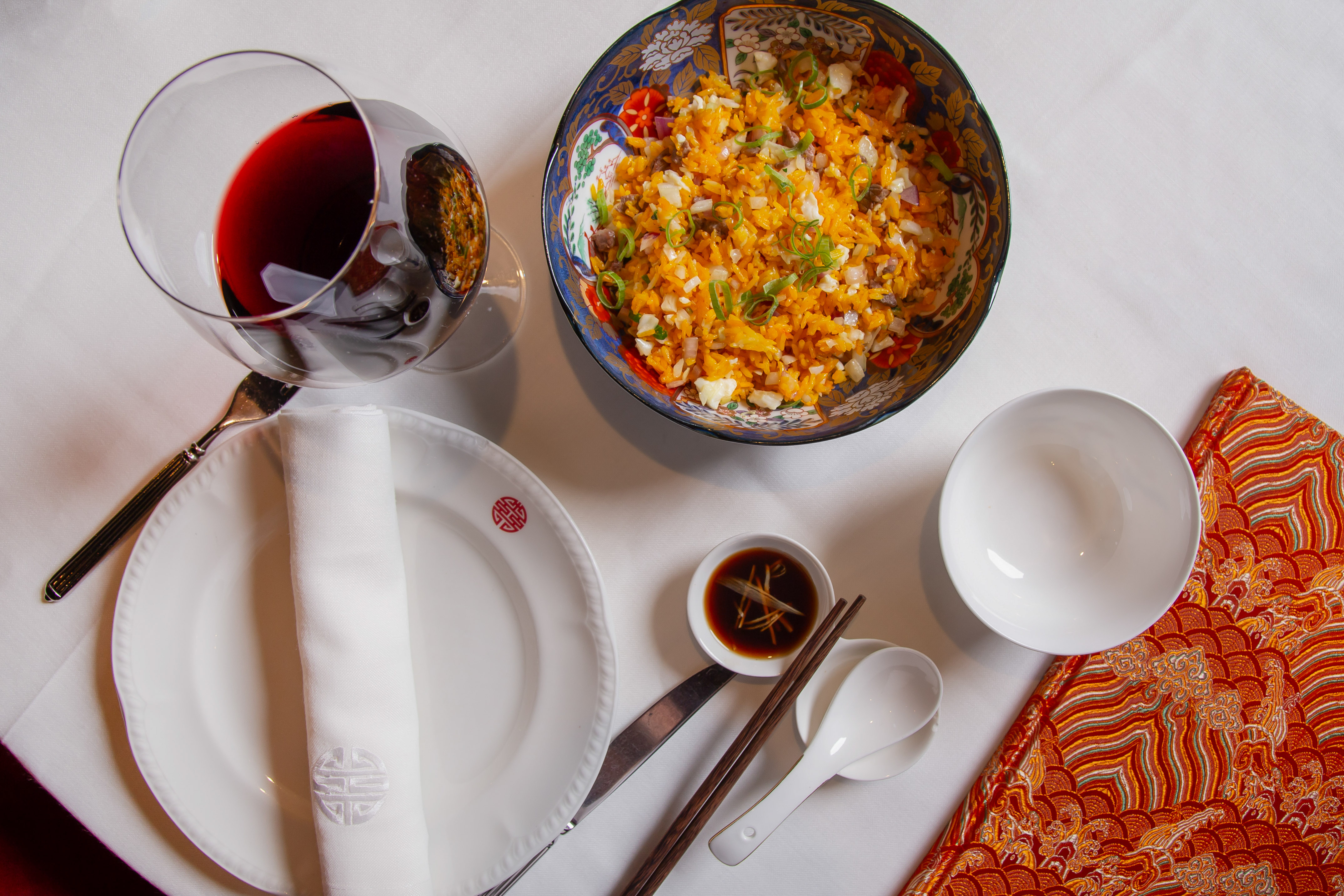 Chinese fried rice, red wine, chopsticks, and elegant restaurant dining.