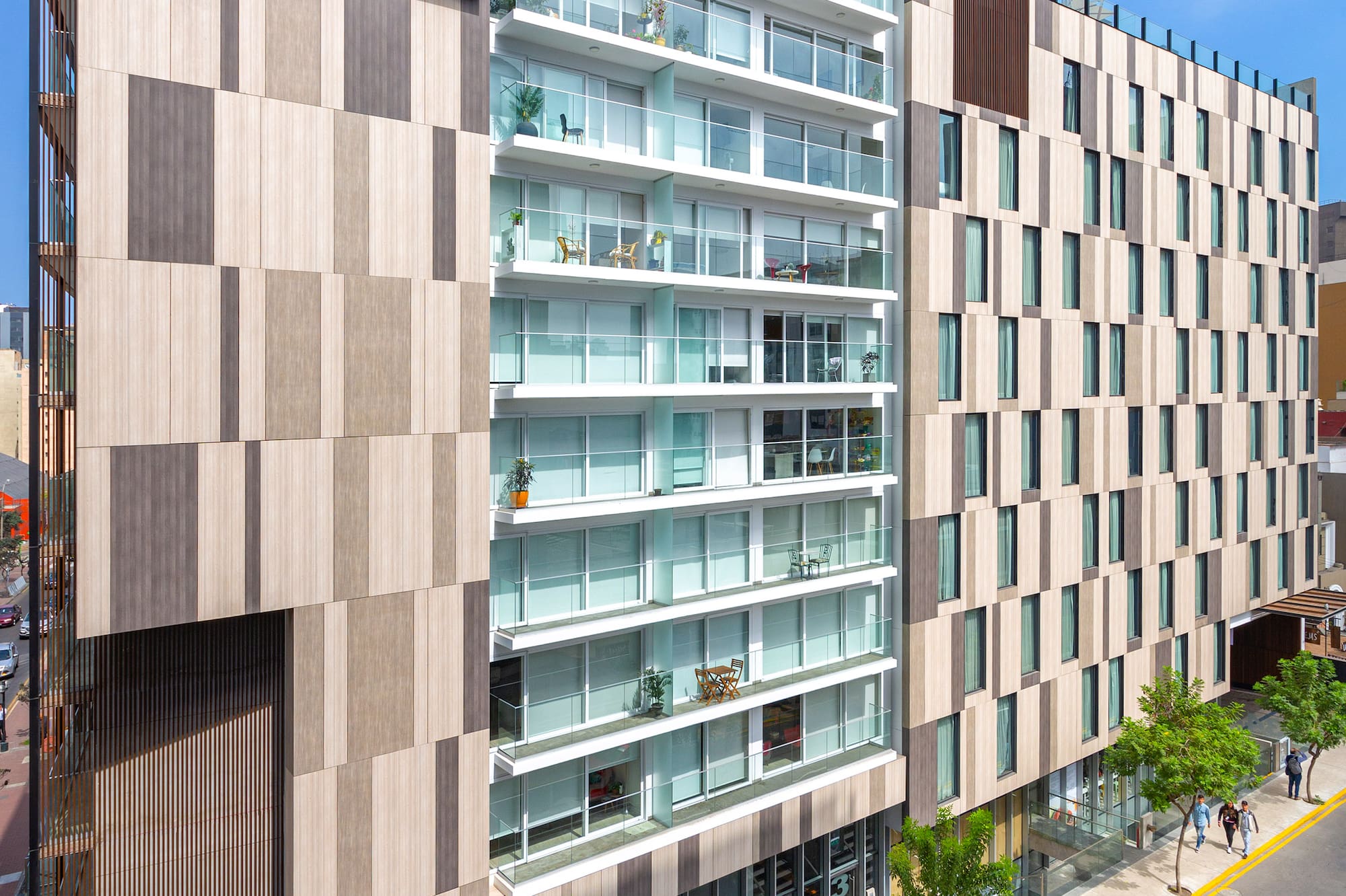 INNSIDE hotel with modern wood panel facade, glass balconies, and urban street view.