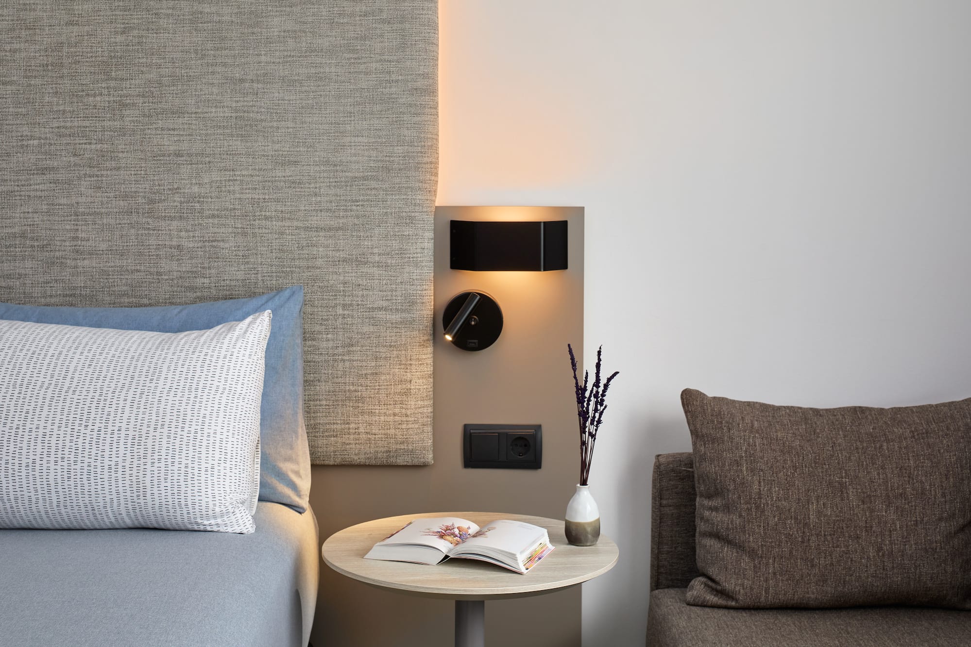 a table with a book and a lamp on the wall