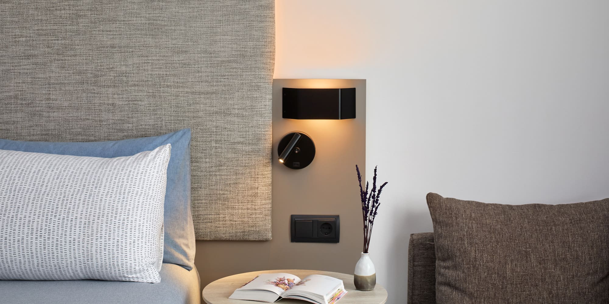 a table with a book and a lamp on the wall