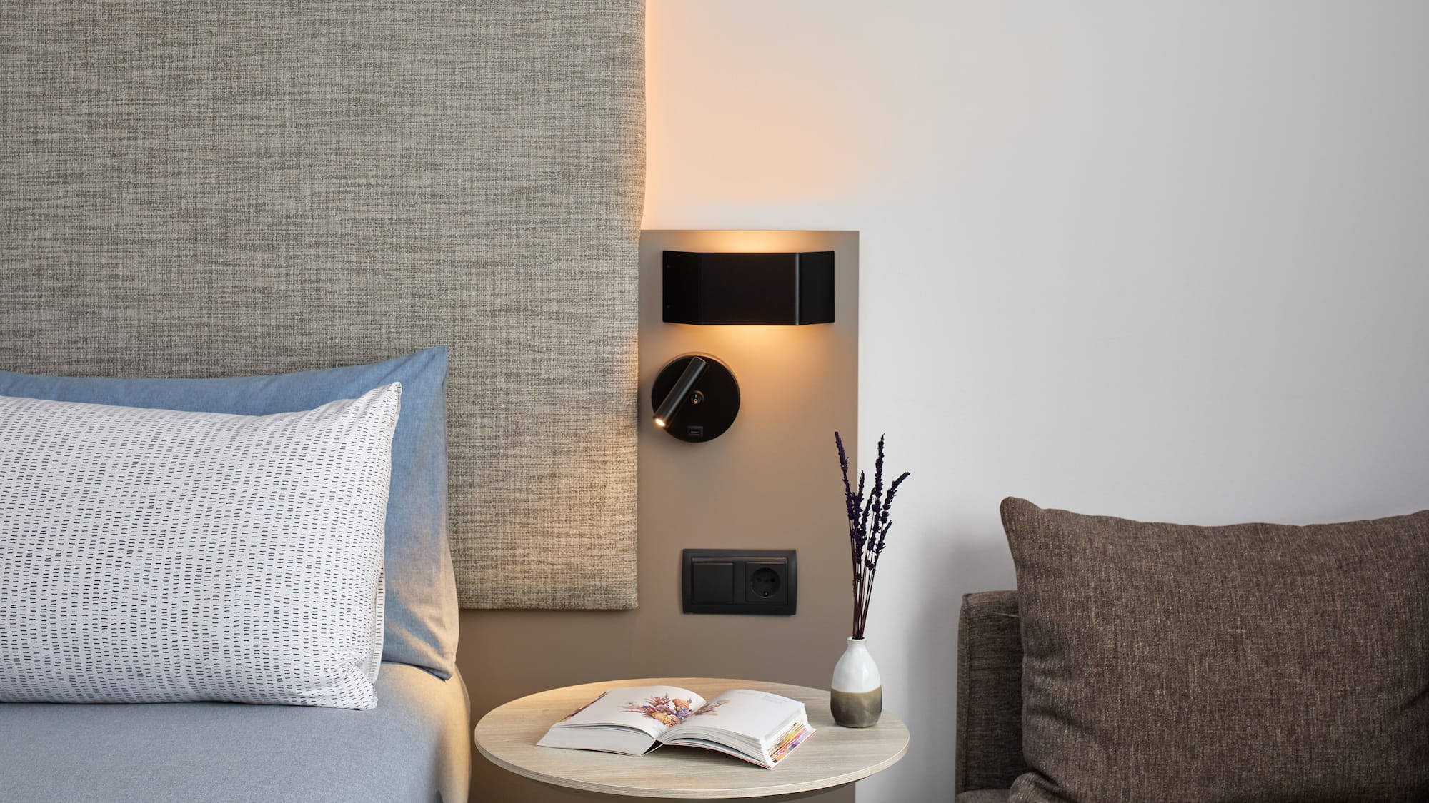 a table with a book and a lamp on the wall