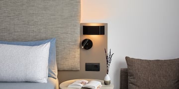 a table with a book and a lamp on the wall