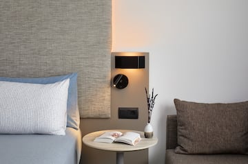 a table with a book and a lamp on the wall