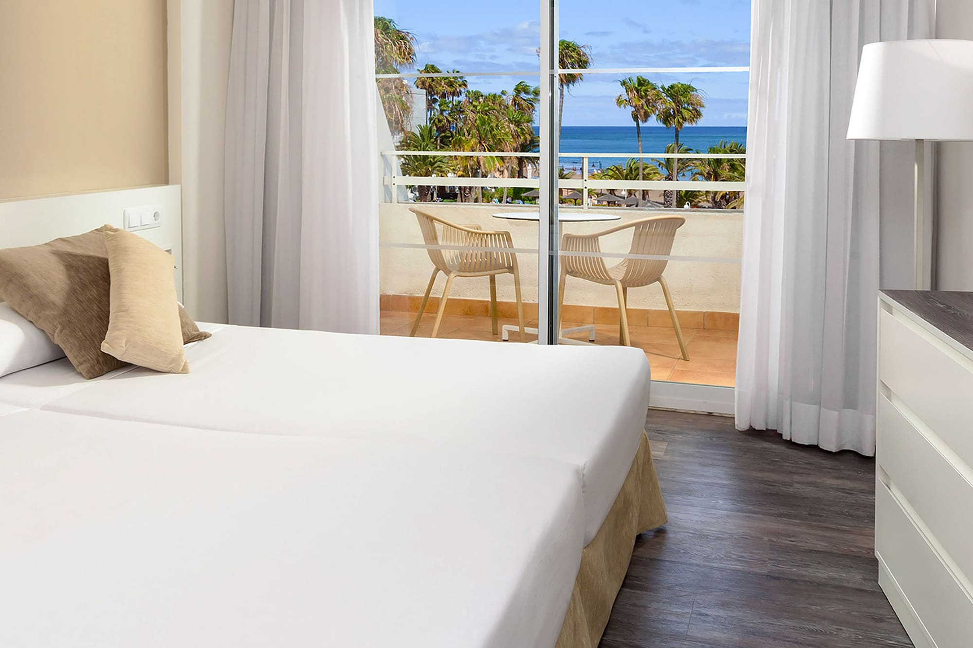 a room with two beds and a glass door