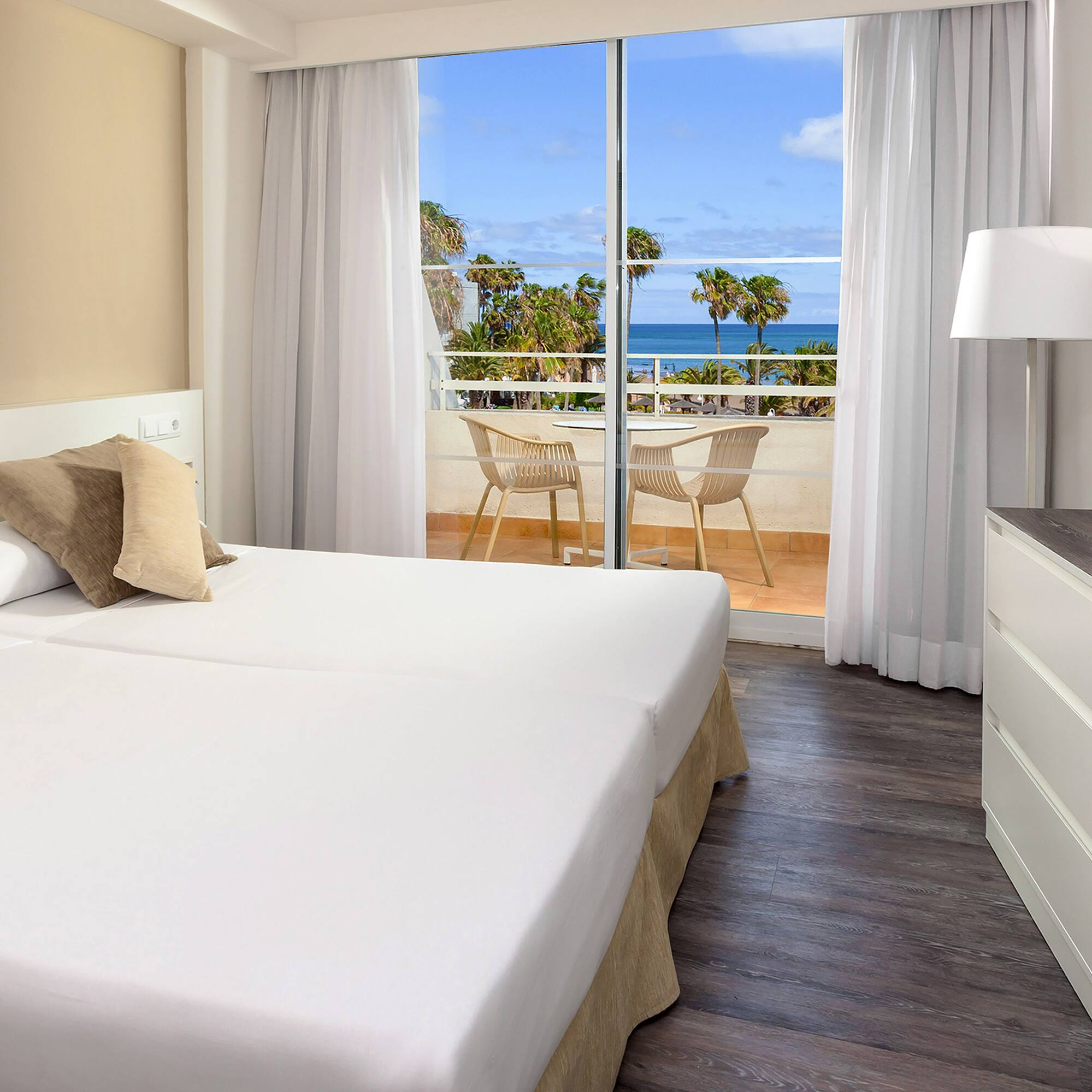 a room with two beds and a glass door