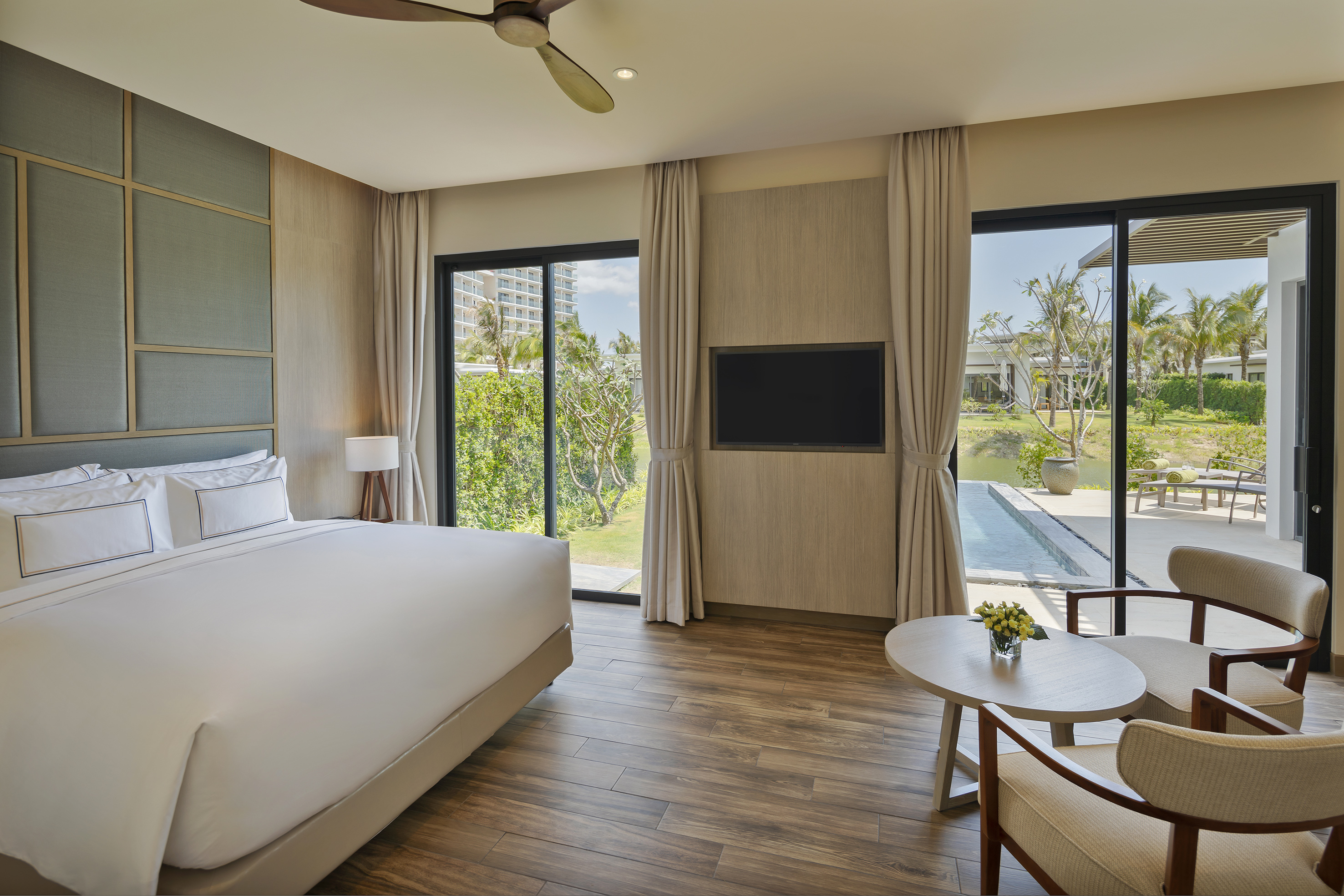 Modern luxury bedroom with private pool access, tropical garden view.