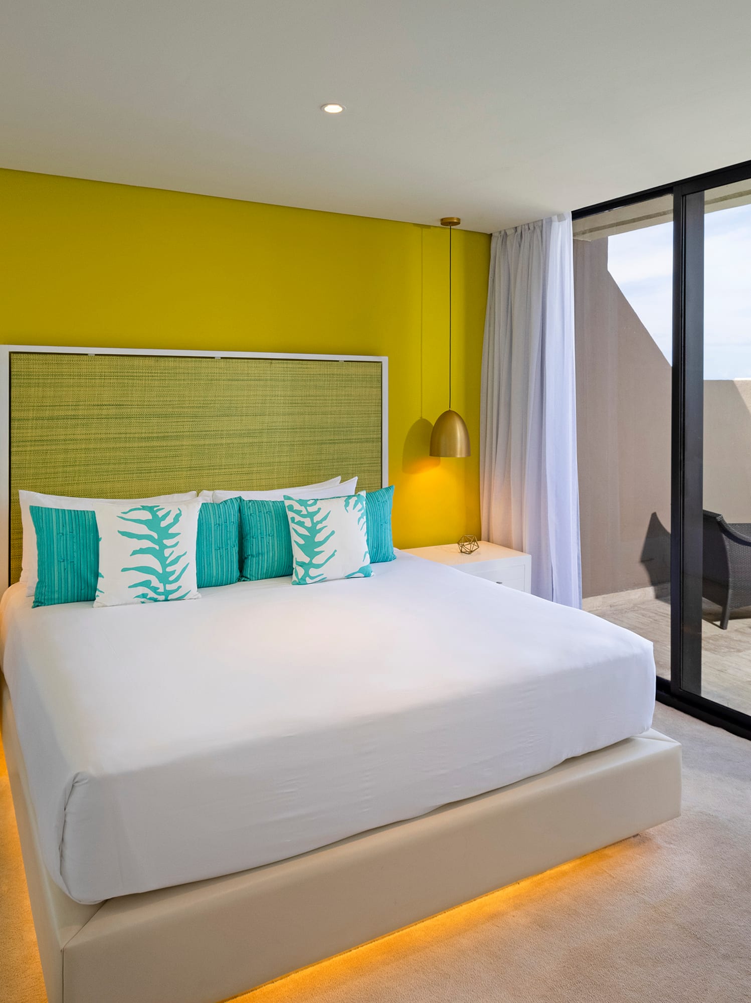 a bedroom with a large bed and a glass door